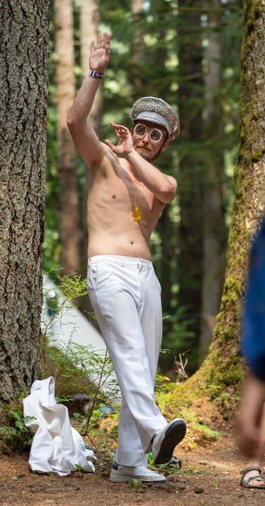 Festival attendee dancing among the trees