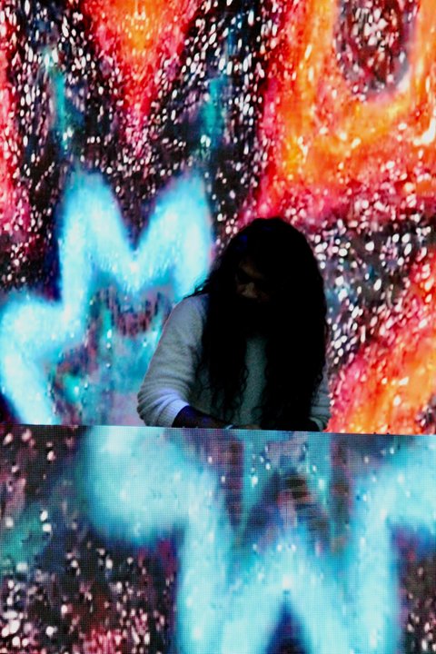 DJ silhouetted against colorful stage visuals