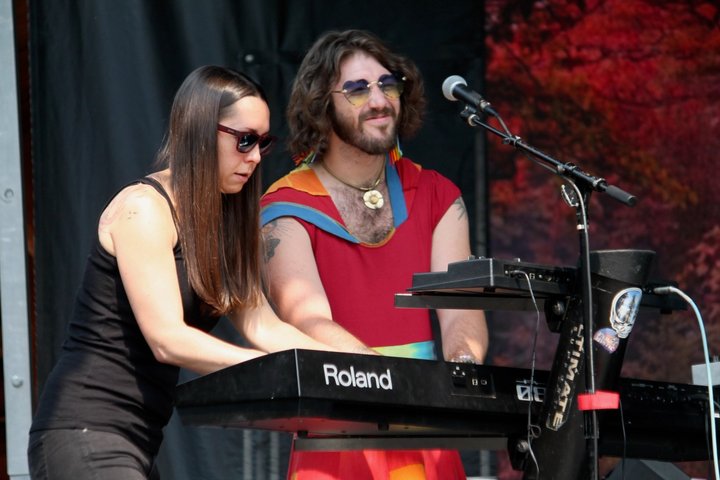 Two musicians performing together at a keyboard and microphone