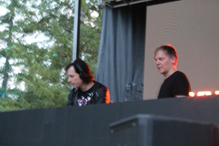 Two electronic musicians performing at a DJ booth