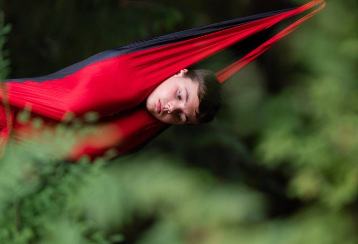 Festival attendee resting in a red hammock